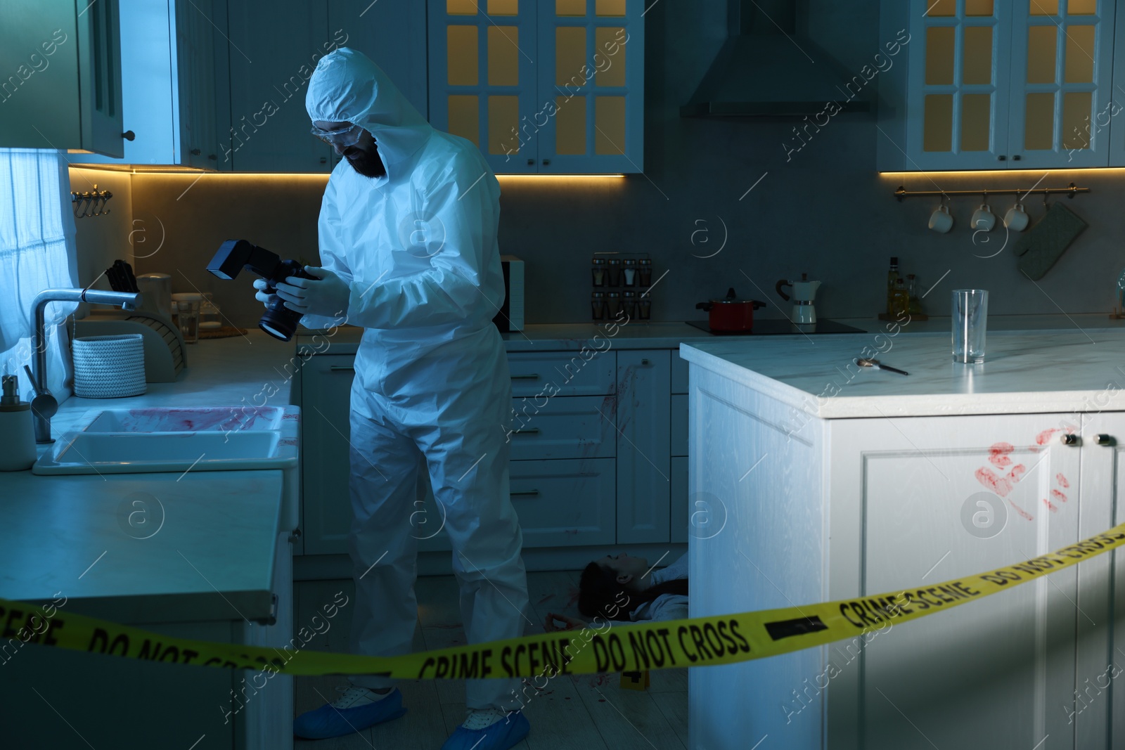 Photo of Forensic expert with camera working at crime scene in dark room