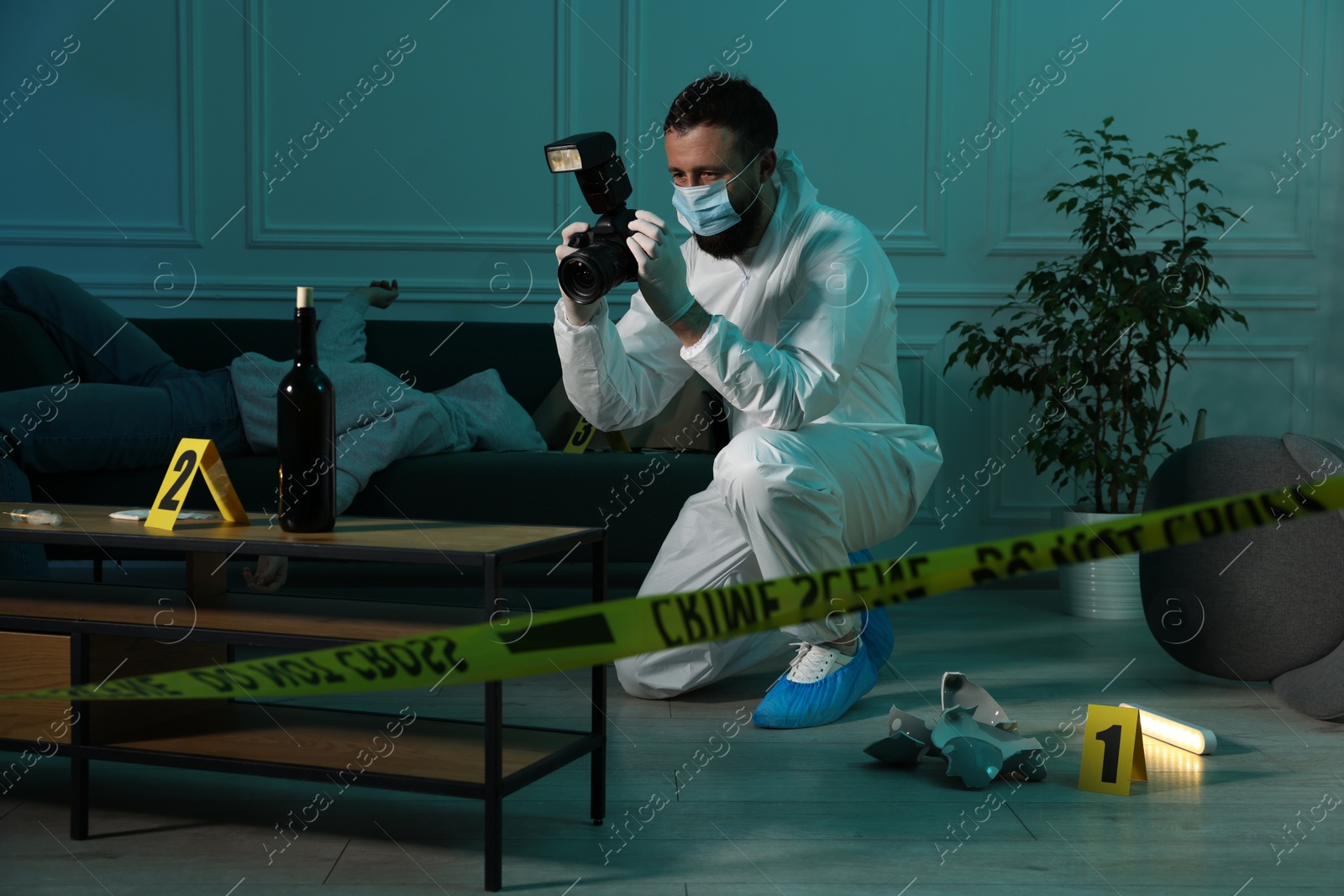 Photo of Forensic expert with camera working at crime scene and dead woman's body indoors