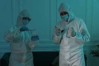 Forensic experts working at crime scene indoors