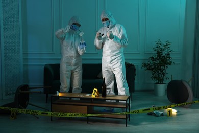 Photo of Forensic experts working at crime scene indoors