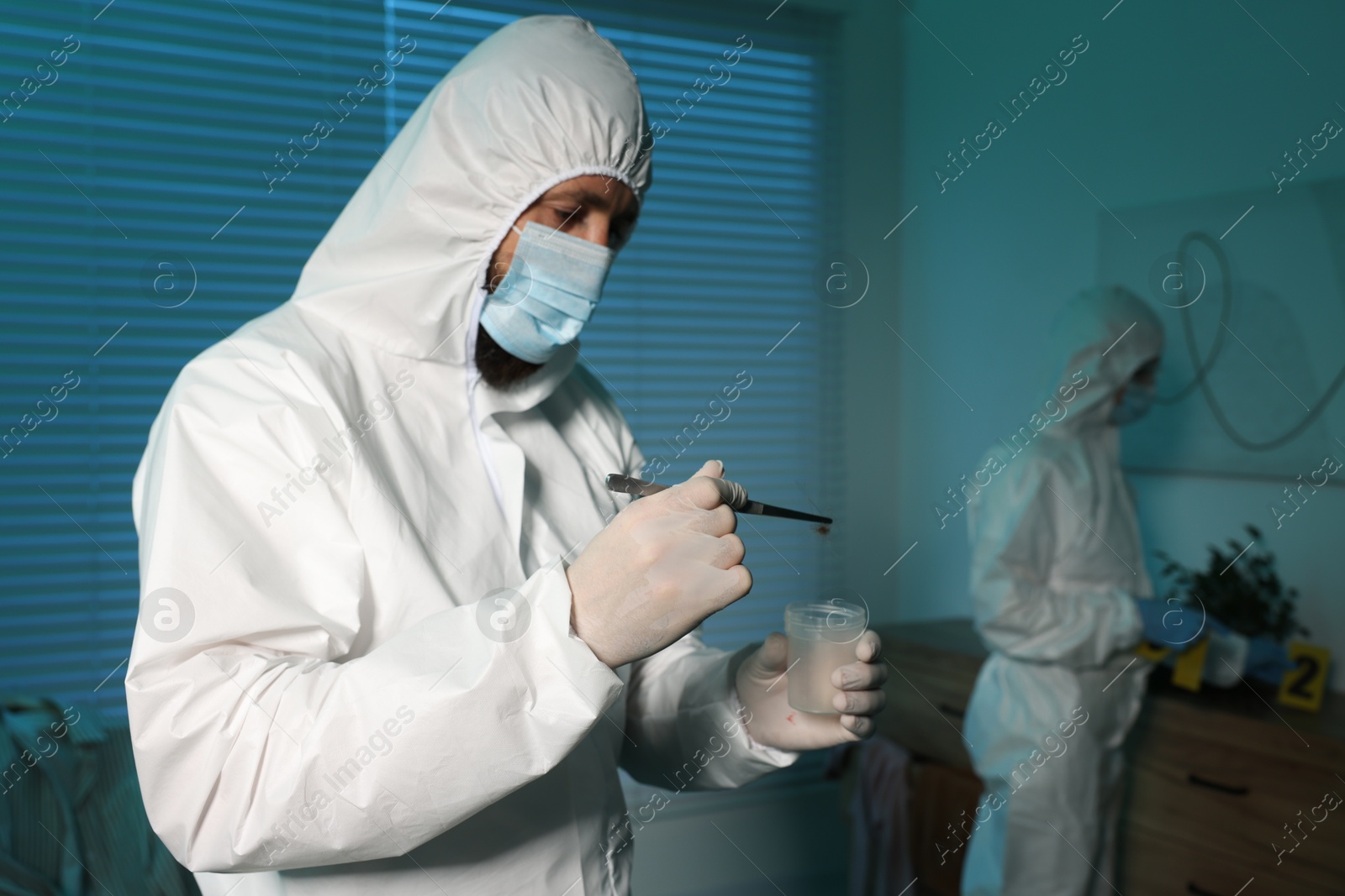 Photo of Forensic experts working at crime scene indoors