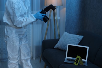 Photo of Forensic expert with camera working at crime scene indoors, closeup