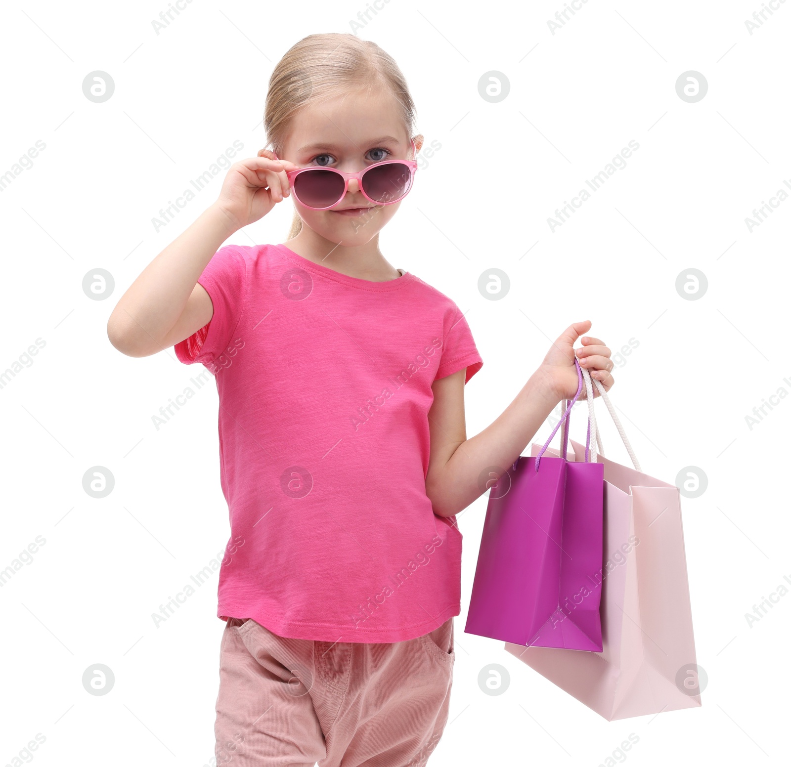 Photo of Little girl with sunglasses and shopping bags on white background