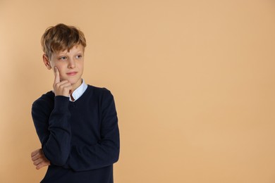 Photo of Portrait of teenage boy on beige background, space for text