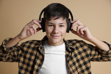 Photo of Portrait of teenage boy in headphones on beige background