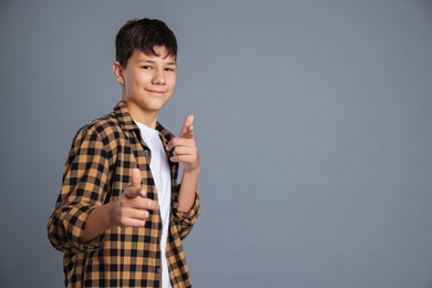 Photo of Portrait of teenage boy on grey background, space for text