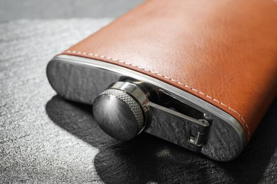 One hip flask on black table, closeup