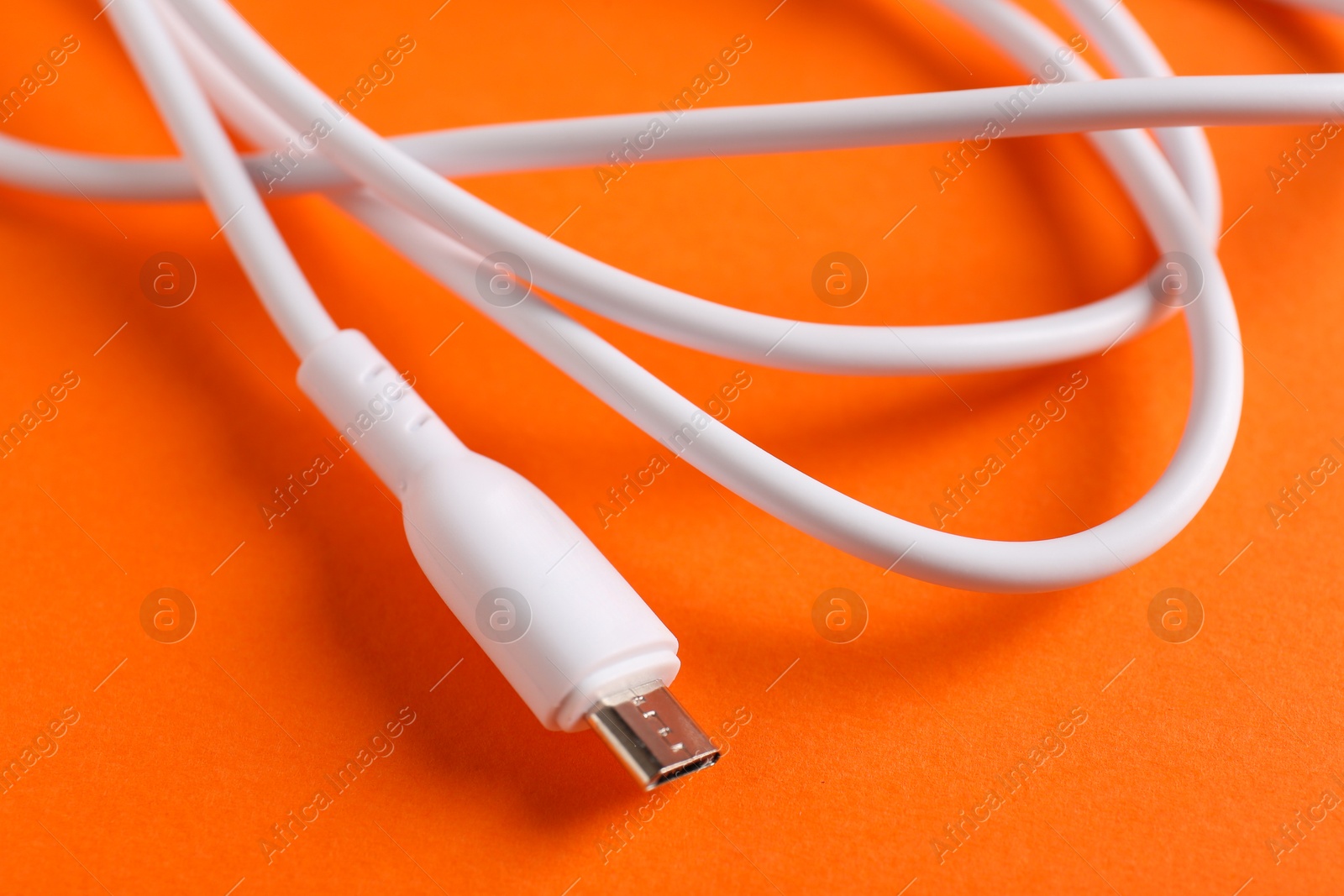 Photo of USB charge cable on orange background, closeup