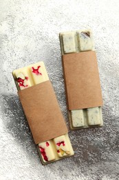 Photo of Delicious chocolate bars with different flavors on silver table, top view