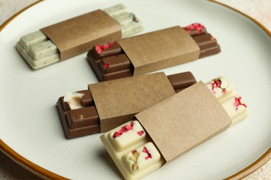 Photo of Delicious chocolate bars with different flavors on light table, closeup