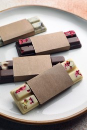 Delicious chocolate bars with different flavors on light table, closeup