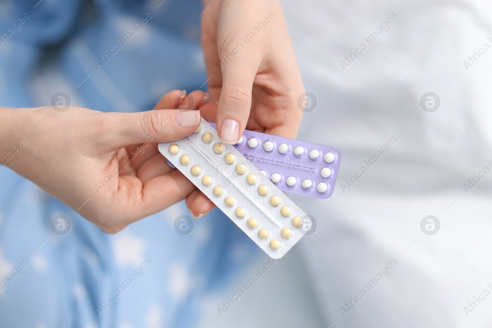 Photo of Woman with blisters of contraceptive pills on bed, closeup. Space for text