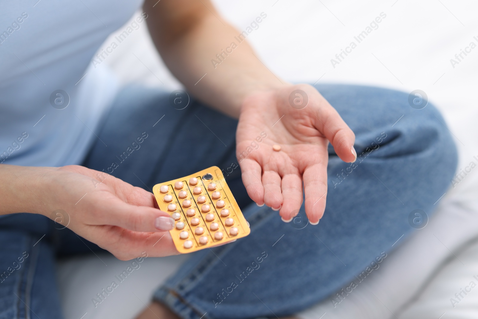 Photo of Woman with contraceptive pills on bed, closeup