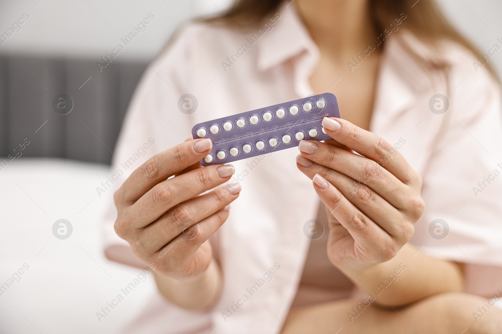 Photo of Woman with blister of contraceptive pills indoors, closeup