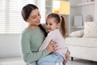 Family portrait of beautiful mother with little daughter at home