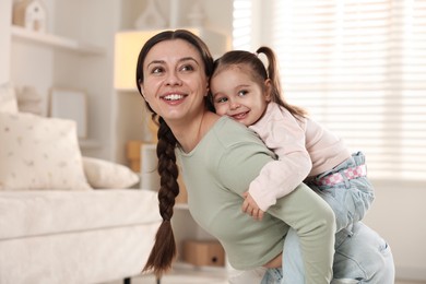 Family portrait of happy mother with cute little daughter at home