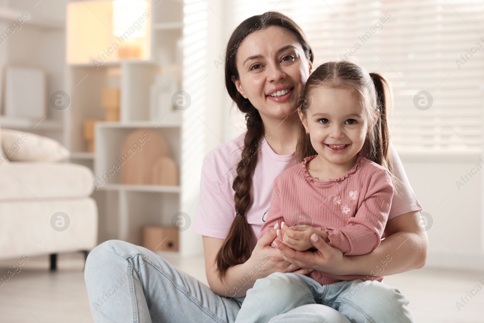 Photo of Family portrait of beautiful mother with little daughter at home. Space for text