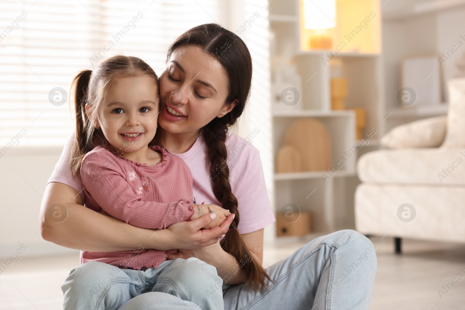 Photo of Family portrait of beautiful mother with little daughter at home. Space for text