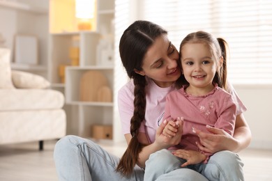 Photo of Family portrait of beautiful mother with little daughter at home. Space for text