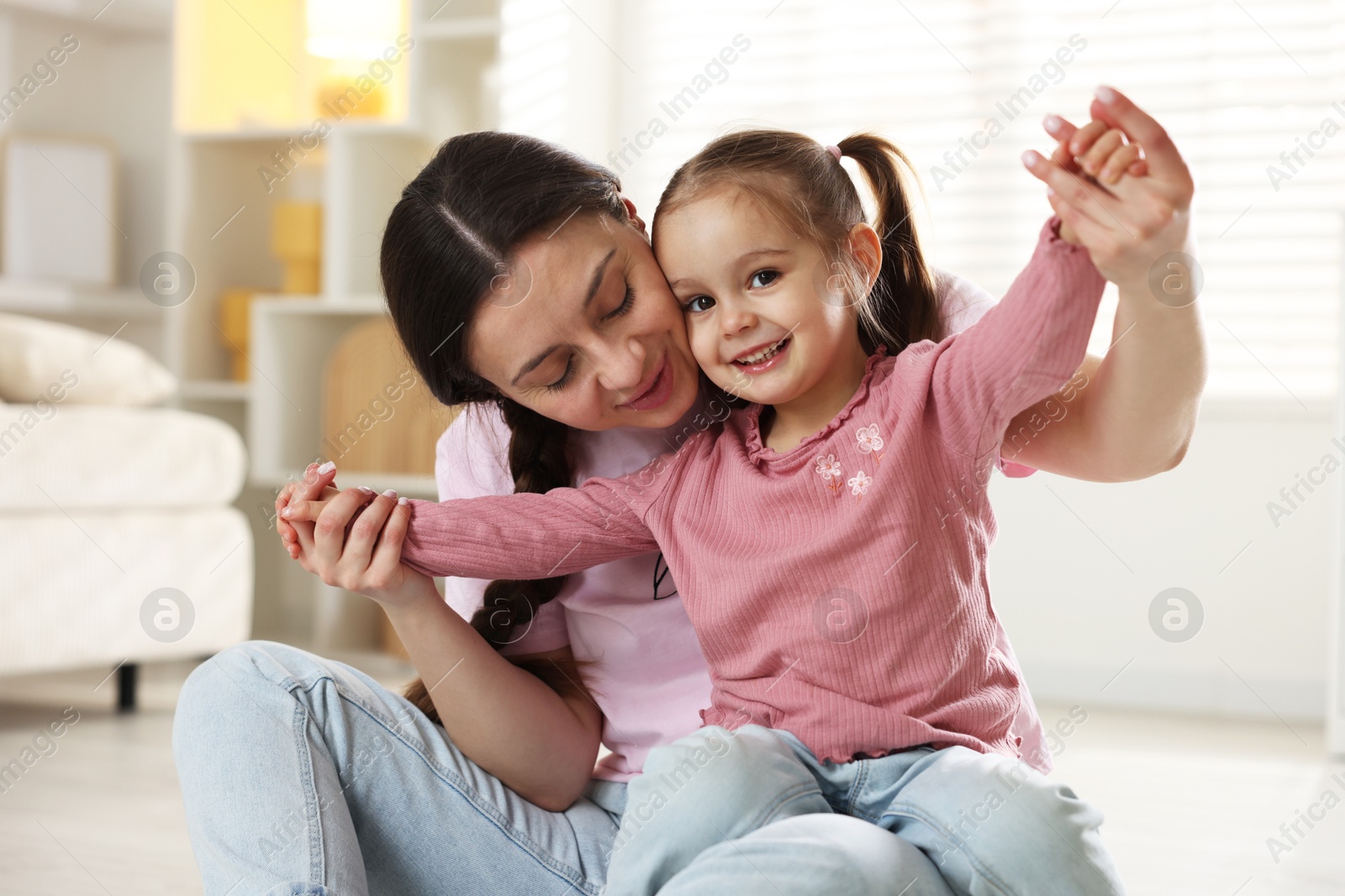 Photo of Family portrait of beautiful mother with little daughter at home