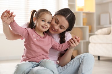 Photo of Family portrait of beautiful mother with little daughter at home