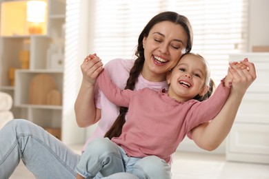 Family portrait of beautiful mother with little daughter at home