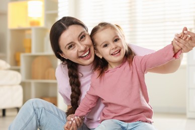 Photo of Family portrait of beautiful mother with little daughter at home