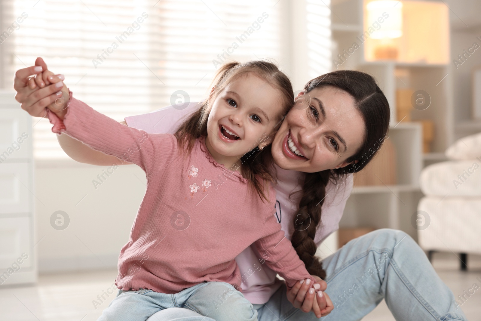 Photo of Family portrait of beautiful mother with little daughter at home