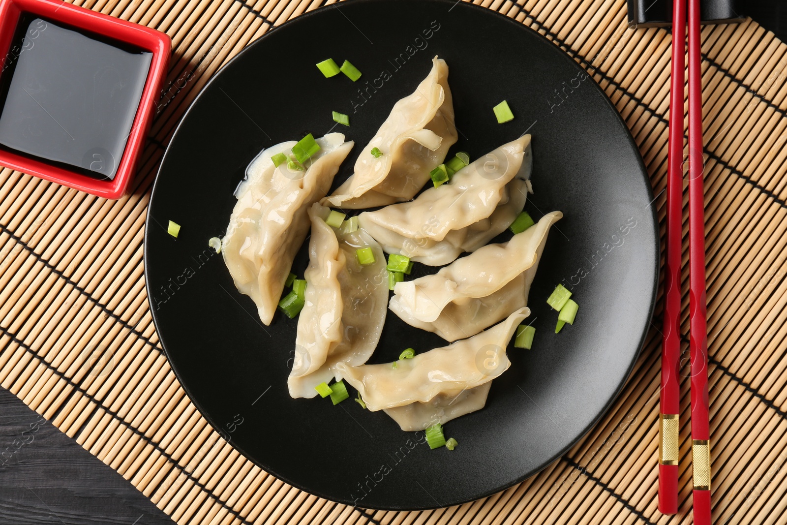 Photo of Delicious gyoza dumplings with chives served on table, top view