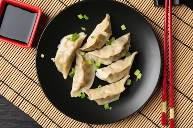 Photo of Delicious gyoza dumplings with chives served on table, top view