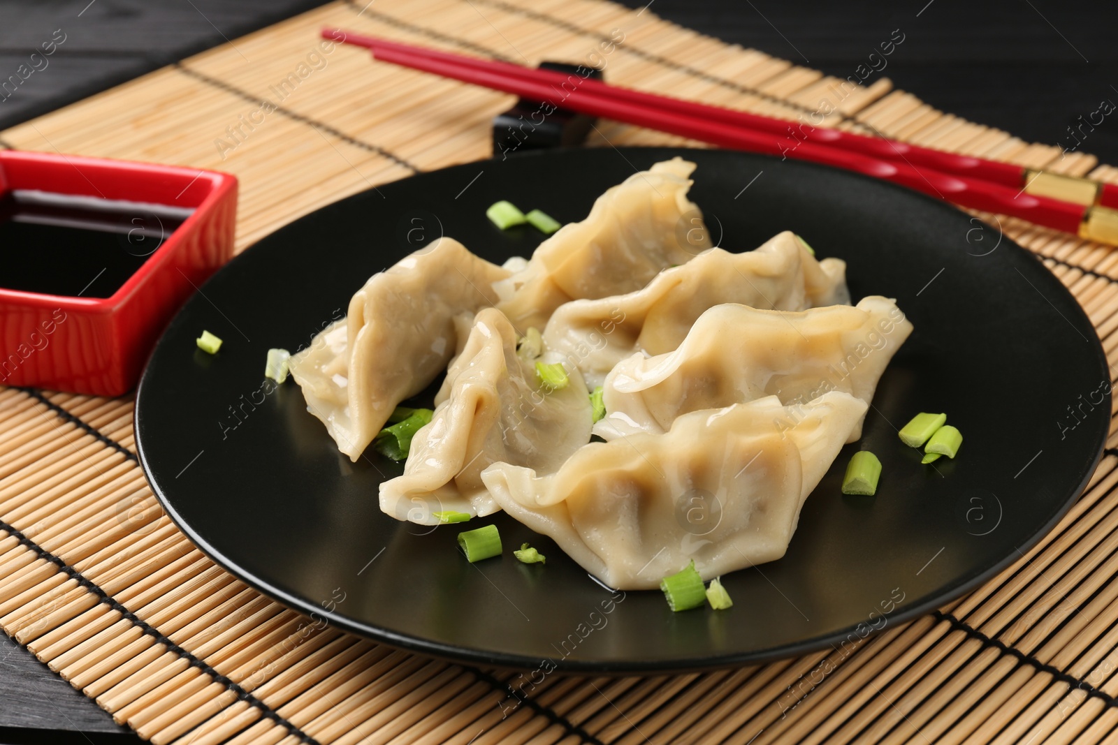 Photo of Delicious gyoza dumplings with chives served on table, closeup