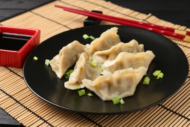 Photo of Delicious gyoza dumplings with chives served on table, closeup