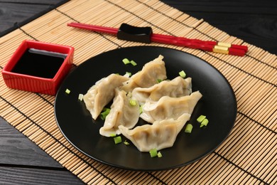 Photo of Delicious gyoza dumplings with chives served on table