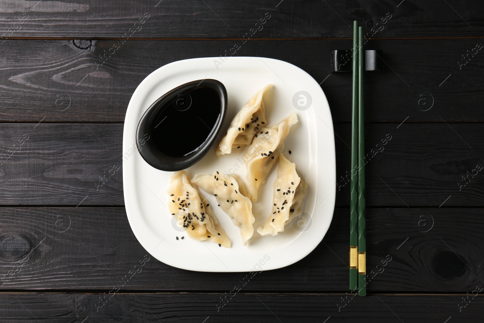 Photo of Delicious gyoza dumplings with sesame seeds served on table, top view