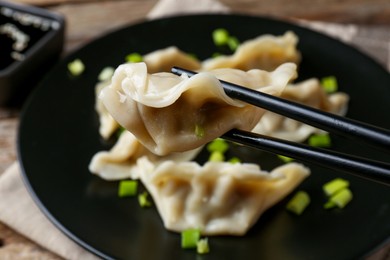 Photo of Eating tasty gyoza dumplings at table, closeup