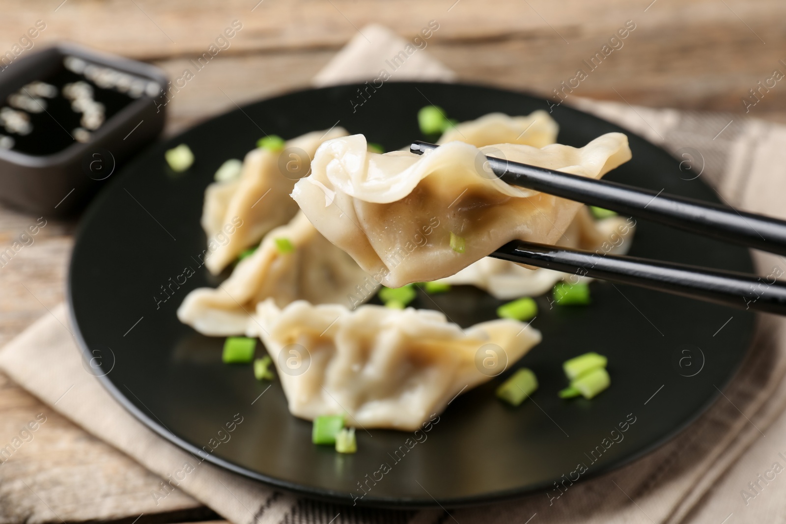 Photo of Eating tasty gyoza dumplings at table, closeup