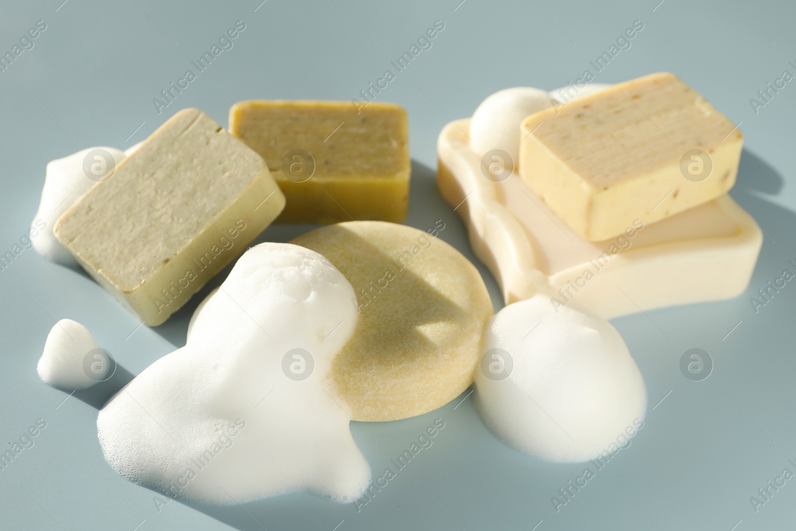 Soap bars with foam on grayish blue background Photo of Soap bars with foam on grayish blue background