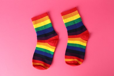 Photo of Pair of socks in LGBT colors on pink background, flat lay