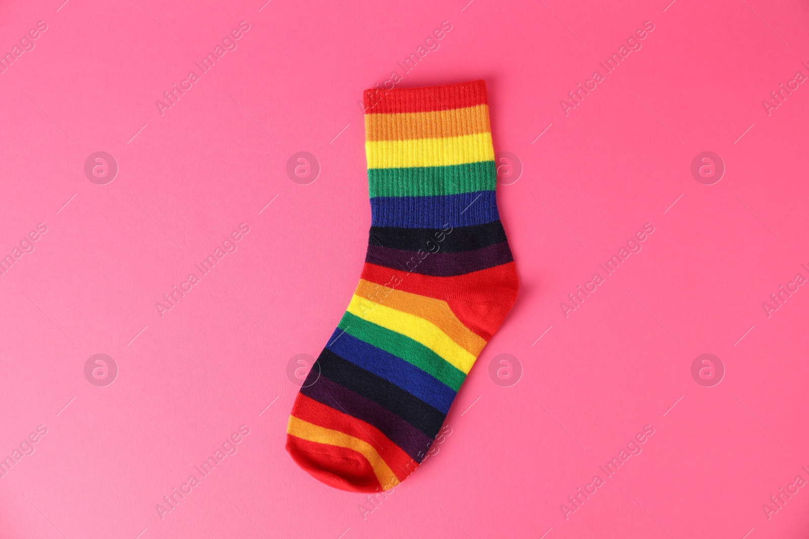 Photo of One sock in LGBT colors on pink background, top view