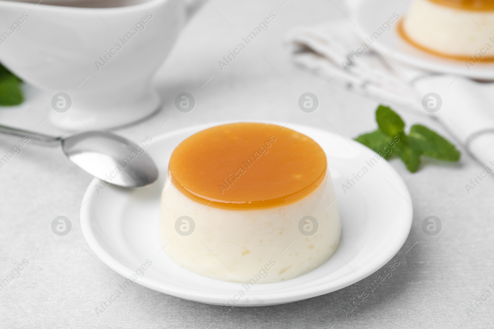 Photo of Tasty pudding with caramel sauce served on white table, closeup