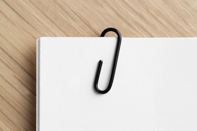 Paper notes with clip on wooden table, top view