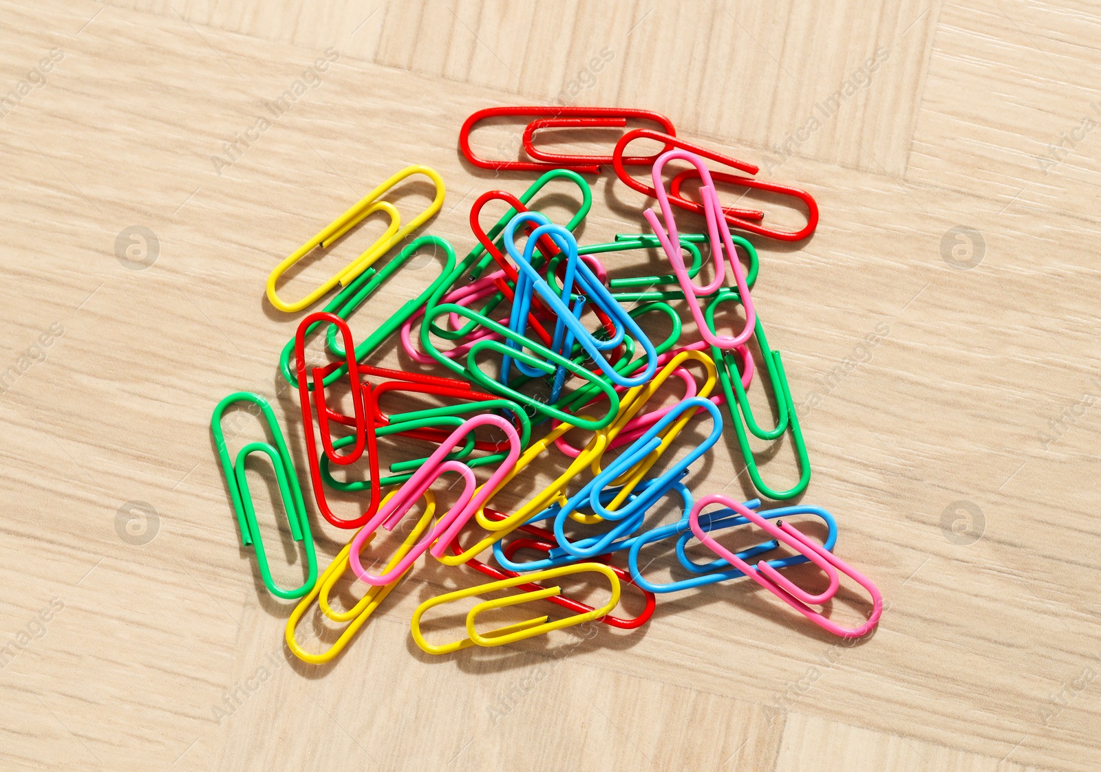 Photo of Many colorful paper clips on wooden table, top view