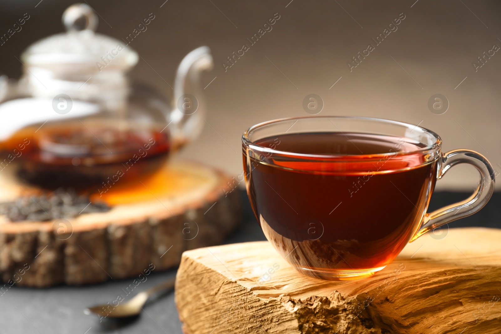 Photo of Aromatic black tea in cup on table, closeup