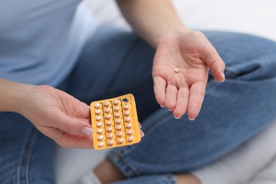 Photo of Woman with contraceptive pills on bed, closeup