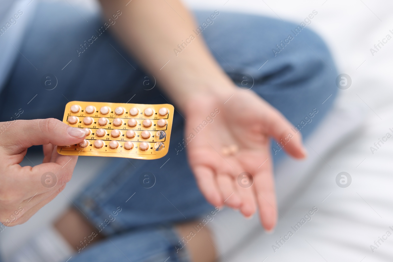 Photo of Woman with contraceptive pills on bed, closeup