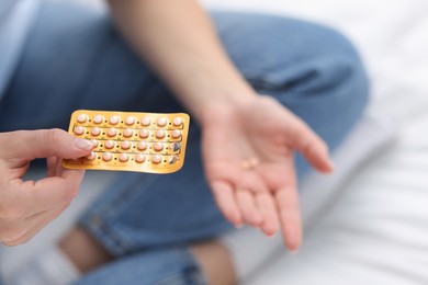 Photo of Woman with contraceptive pills on bed, closeup