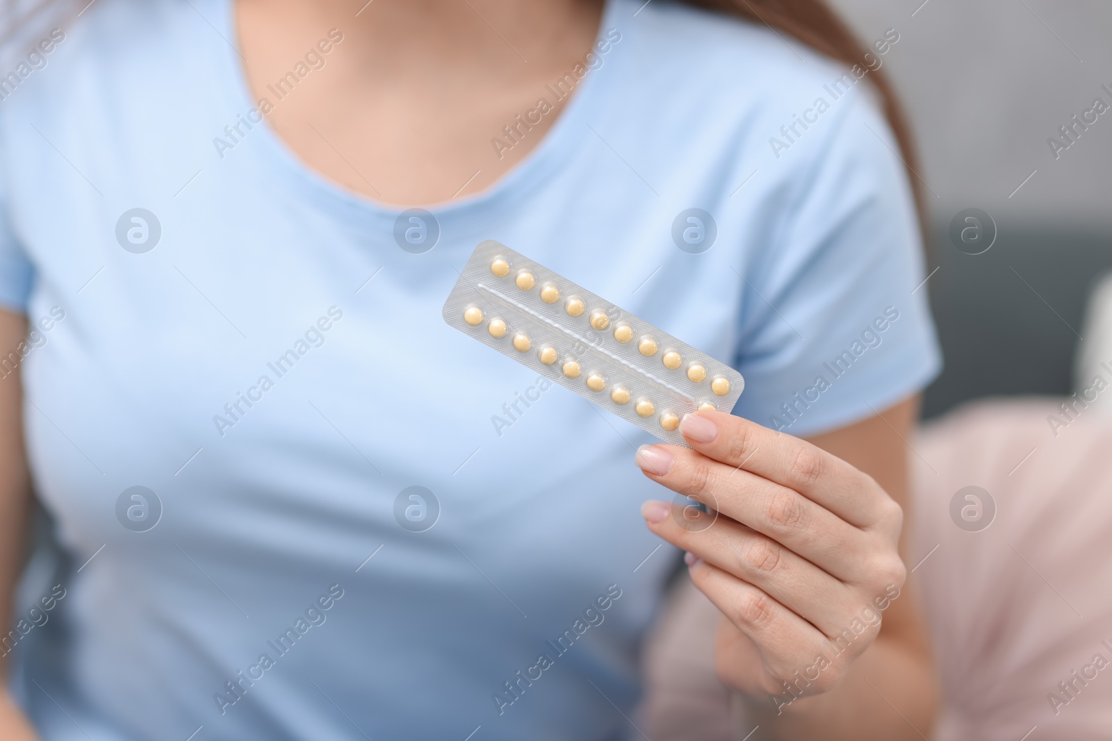 Photo of Woman with blister of contraceptive pills indoors, closeup