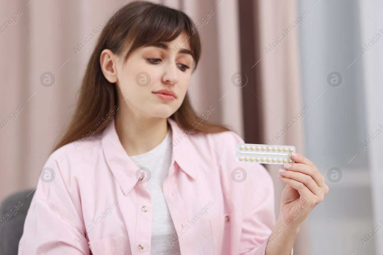 Photo of Woman with blister of contraceptive pills indoors