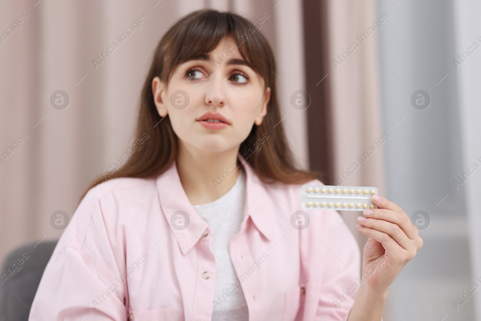 Photo of Woman with blister of contraceptive pills indoors