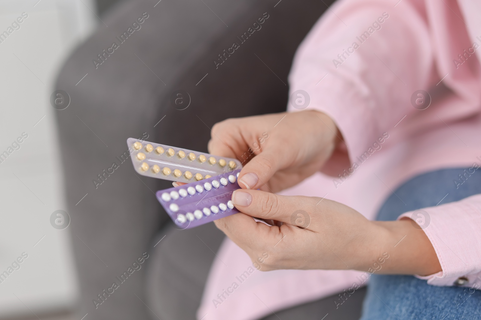 Photo of Woman with blisters of contraceptive pills indoors, closeup